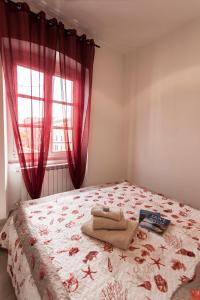 ラ・スペツィアにあるByron & Shelley Apartmentsのベッドルーム1室(赤いカーテンと窓付きのベッド1台付)