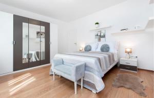 a white bedroom with a large bed and a chair at Gorgeous Home In Rovinj in Rovinj