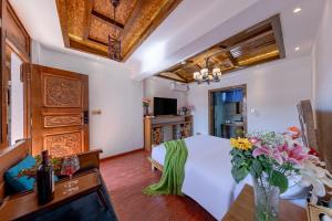 a bedroom with a white bed and a table with flowers at 古城区瑾琳客栈 in Lijiang