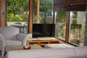 un soggiorno con una TV, un divano e un tavolo di Varkiza's Cottages a Varkiza