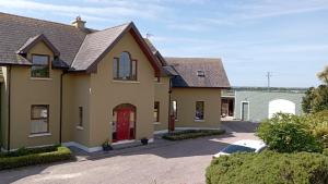 a house with a red door and a driveway at Lighthouse view in Garryvoe