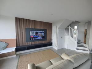 a living room with a couch and a flat screen tv at Lighthouse view in Garryvoe