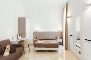 モンテスカリオーゾにあるForesteria dell'Abbaziaのベッド1台とソファが備わる小さな客室です。