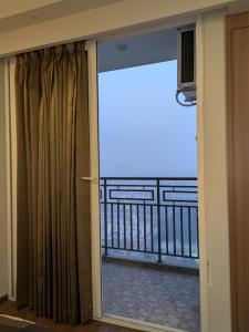 a room with a view of a balcony at Omaxe Air B&B in Greater Noida +4 photos