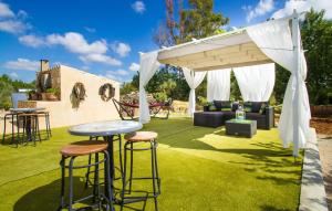 a patio with a table and stools under a pavilion at Esplendor in Campos +37 photos