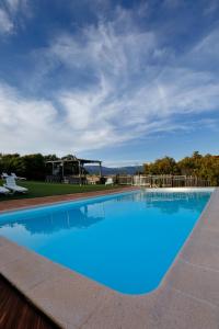 a large blue swimming pool with a cloudy sky at Hotel Restaurante Port d'Ager in Àger