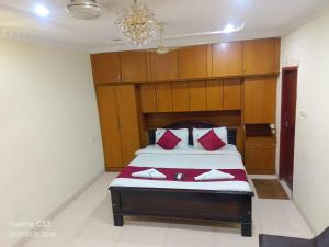 a bedroom with a bed with red pillows at Hotel Raaj Inn Service Apartment in Chennai