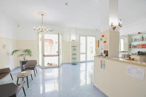 a large white kitchen with chairs and a counter at Hotel da ettore in Porto Cesareo
