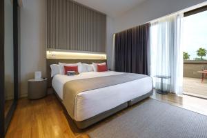 a bedroom with a large bed and a large window at Hotel Kivir in Seville