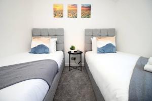 two beds sitting next to each other in a room at Afan House by STAE-Homes in Glyncorrwg