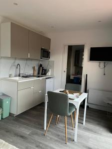 a kitchen with a table and a white table and chairs at Sof tiny in Moyenmoutier