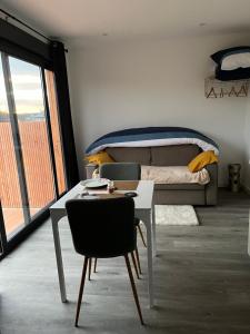 a bedroom with a bed and a table and chairs at Sof tiny in Moyenmoutier