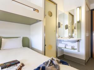 a hotel room with a bed and a sink at ibis budget Antwerpen Centraal Station in Antwerp +55 photos