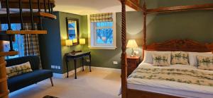 a bedroom with a canopy bed and a chair at Butt Lodge in Lochranza