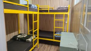 a room with two bunk beds and a table at Hills Vacation Hostel in Darjeeling +5 photos
