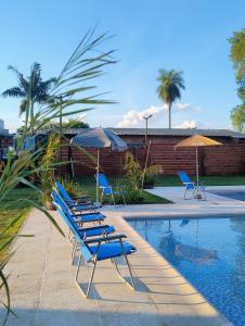a group of chairs and umbrellas next to a pool at Rdsa Paso in Paso de la Patria