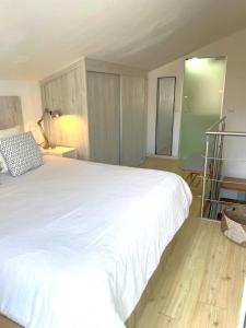 a bedroom with a large white bed and a desk at Don Sebastiao in Sesimbra