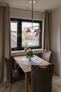 a dining room with a table and chairs and a window at Panorama-Blick Brüggen in Brüggen