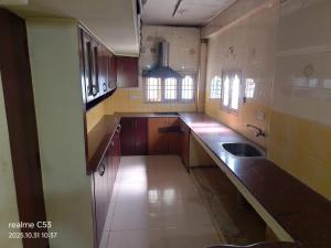 a large kitchen with wooden cabinets and a sink at Hotel Raaj Inn Service Apartment in Chennai