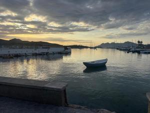 a small boat in the water in a harbor at Spacious open plan ground floor apartment in Port de Pollensa