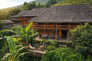 two people sitting in front of a house at Surelee Homestay & Sapa Trekking Tours by Local Path in Sapa