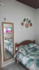 a bedroom with a mirror and a bed and a television at Loft Hipolito in Belém