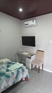 a bedroom with a bed and a desk and a tv at Loft Hipolito in Belém