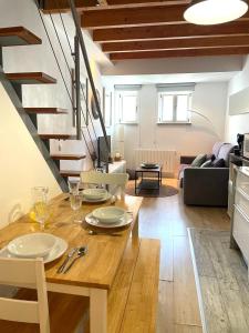 a dining room and living room with a table and stairs at Don Sebastiao in Sesimbra