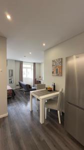 a kitchen and living room with a table and a refrigerator at Gold Center Funchal 101 in Funchal