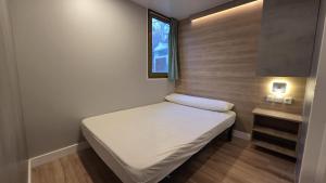 a small bed in a small room with a window at Camping Bungalows Mariola in Bocairent +27 photos