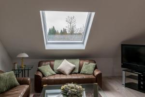 a living room with a couch and a window at Panorama-Blick Brüggen in Brüggen