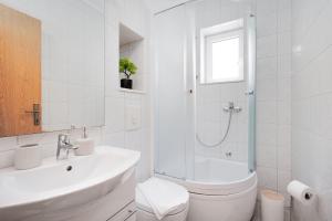 a white bathroom with a sink and a shower at Apartment Bernarda in Igrane +10 photos