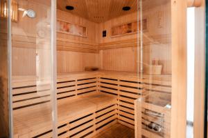a sauna with wooden panels and a glass wall at Stay4U Apartments Belle View in Szklarska Poręba
