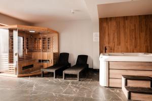 a bathroom with two chairs and a bath tub at Stay4U Apartments Belle View in Szklarska Poręba