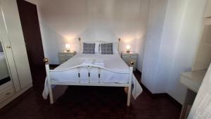a bedroom with a white bed with two lamps on it at Varandas do Dão & Estrela in Pardieiros +16 photos