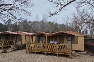 a small house with a porch and a wooden fence at Camping Bungalows Mariola in Bocairent