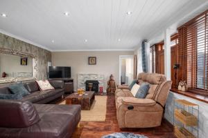 a living room with leather furniture and a fireplace at Historic 4BR Home - The Old Bakehouse in Llandysul