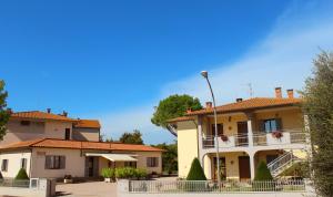 カスティリオーネ・デル・ラーゴにあるAgriturismo La Pianaの青空を背景にした一群の家