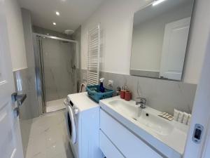 a white bathroom with a sink and a washing machine at Mono Giudici in Clusone