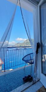 a view of the ocean from a balcony with a camera at Panoramic Sea View Balcony Apartment in the Heart of Praiano, Casa Mimì Junior in Praiano