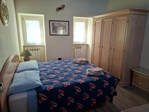 a bedroom with a bed with a blue comforter at La corte in Vezzo