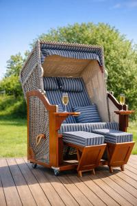 a wicker chair with a table and wine glasses at Villa Silbermöwe in Trent