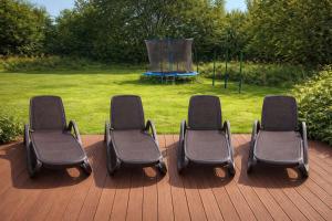 four chairs sitting on a deck with a playground at Villa Silbermöwe in Trent