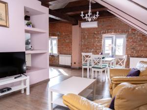 a living room with a couch and a tv and a table at Nowy Rynek 10 in Płock