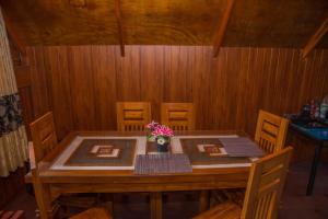 a wooden table with a vase of flowers on it at Cloud Nest Cabana in Ohiya +16 photos