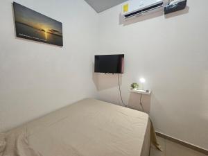 a bedroom with a bed and a flat screen tv at Casa Márquez in San Miguel