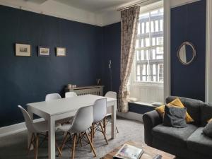a blue living room with a table and chairs at The Gingernut in Ross on Wye