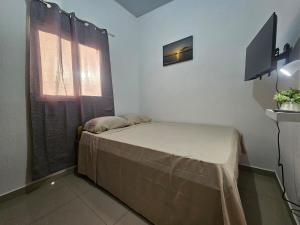 a small bedroom with a bed and a television at Casa Márquez in San Miguel +21 photos