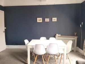 a dining room with a white table and white chairs at The Gingernut in Ross on Wye