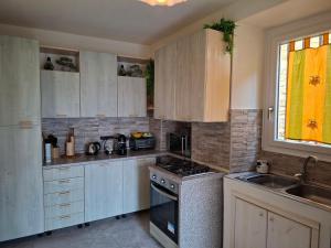 a kitchen with white cabinets and a stove top oven at La corte in Vezzo +15 photos